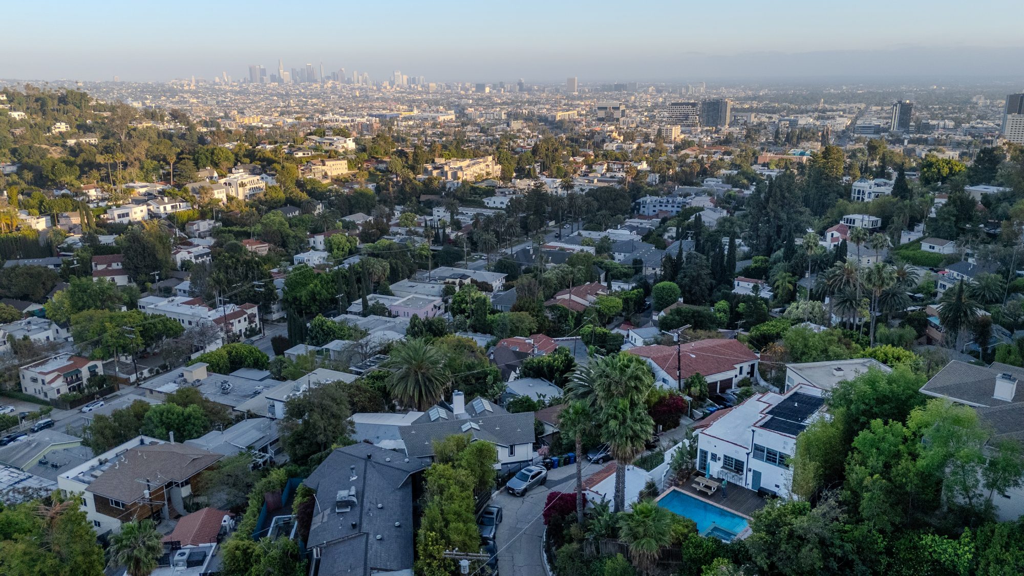 Aerial view looking southeast over Beachwood Canyon rooftops to the downtown Los Angeles skyline