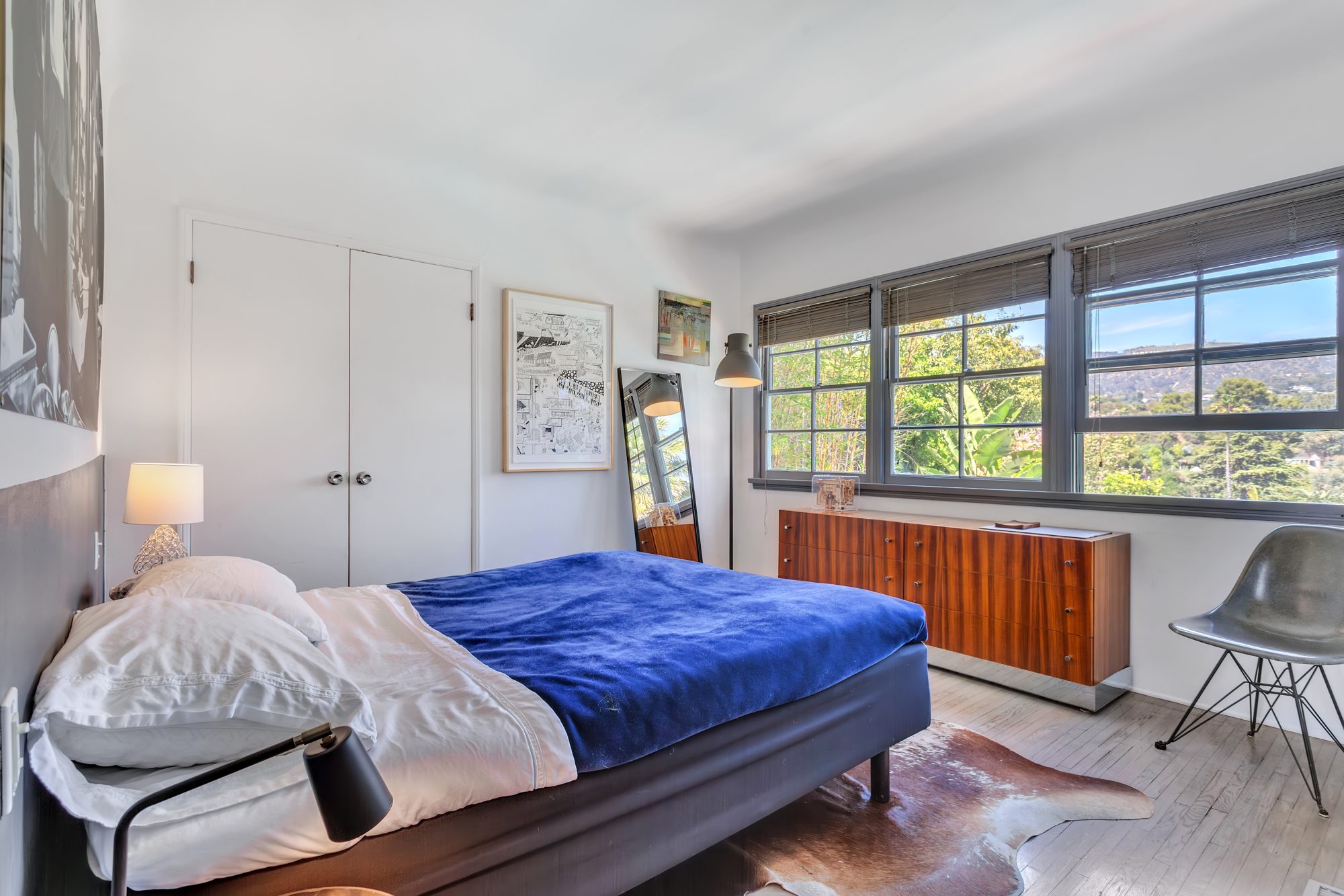 Second bedroom with double closets, hardwood floors, and windows looking to the hills